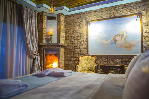 a bedroom with a bed and a painting and a fireplace at Morfeas Guesthouse in Kato Loutraki