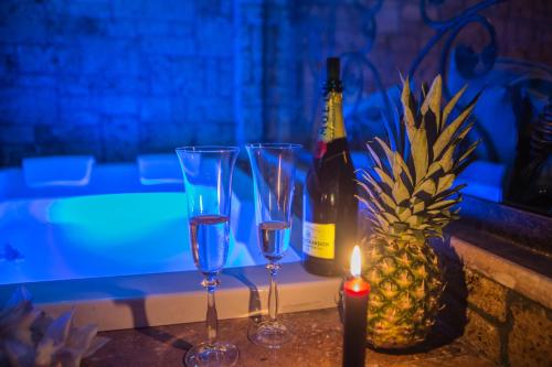 a table with glasses and a bottle of wine and a pineapple at Morfeas Guesthouse in Kato Loutraki