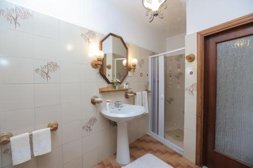 W łazience znajduje się umywalka, lustro i prysznic. w obiekcie Villa Marietta w mieście Minori