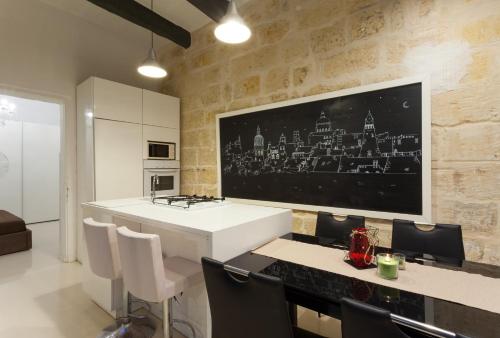 a kitchen with a large tv on a brick wall at Your Apartment in Il-Furjana