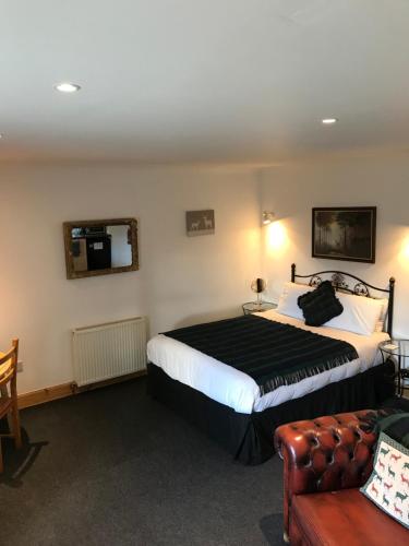 a hotel room with a bed and a couch at Garrison Farm with Hot Tub in Inversnaid