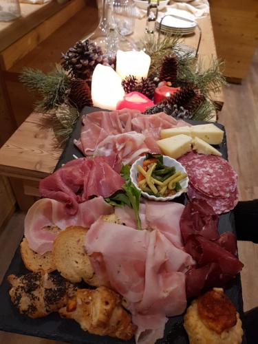a tray of meat and other foods on a table at Hotel Pedretti in Branzi
