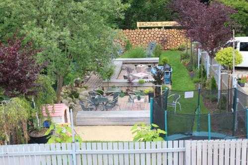 a garden with a white fence and a fountain at Apartmá SunGarden Liberec in Liberec
