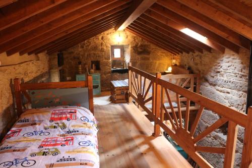 um quarto com uma cama num edifício de pedra em Bodega rural tipo loft em Ourense