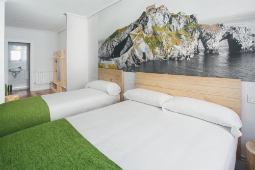 2 Betten in einem Zimmer mit Wandgemälde in der Unterkunft Casual Serantes in Bilbao