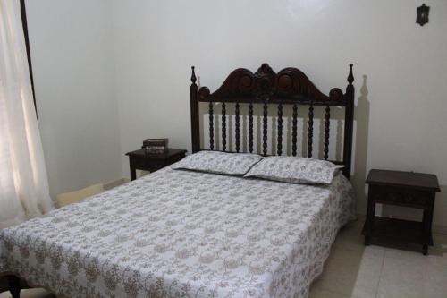 a bedroom with a large bed with a wooden headboard at Sobrado em Arraial do Cabo in Arraial do Cabo