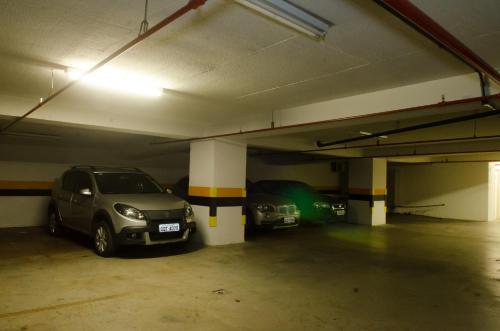 a parking garage with two cars parked in it at Hotel Beaga Convention Expominas by MHB in Belo Horizonte