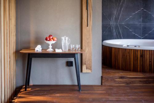 a table with a bowl of fruit on it next to a bath tub at KOS Pilar Hotel in Pilar