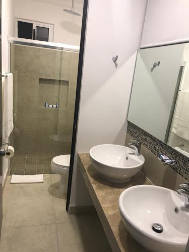 a bathroom with a sink and a toilet and a shower at Liverté Armonia 102 in Cancún