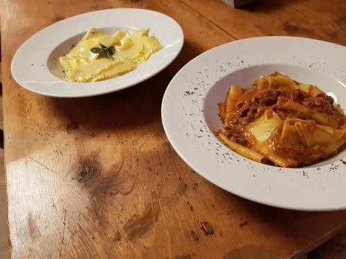 two plates of food on a wooden table at Hotel Pedretti in Branzi
