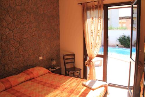 a bedroom with a bed and a view of a pool at Il Quadrifoglio in Trapani
