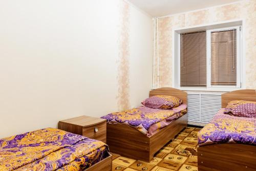 Cette chambre comprend 2 lits et une fenêtre. dans l'établissement Apartment TwoPillows on Mayakovskogo 3, à Vorkuta