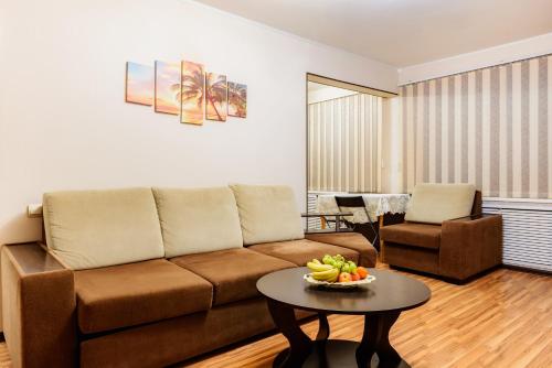 - un salon avec un canapé et une table avec un bol de fruits dans l'établissement Apartment TwoPillows on Mayakovskogo 3, à Vorkuta