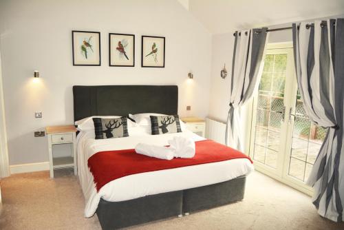 a bedroom with a bed with a red blanket at Campion Lodge in Chappel
