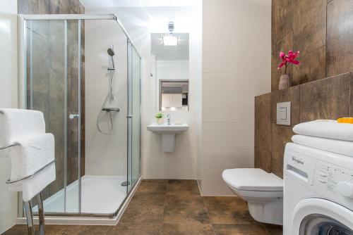 La salle de bains est pourvue d'une douche, de toilettes et d'un lavabo. dans l'établissement P&O Giełdowa Serviced Apartments, à Varsovie