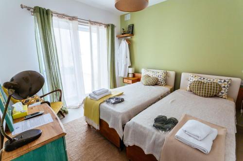 1 dormitorio con 2 camas, escritorio y ventana en Ghand in-Nanna B&B en Mellieħa