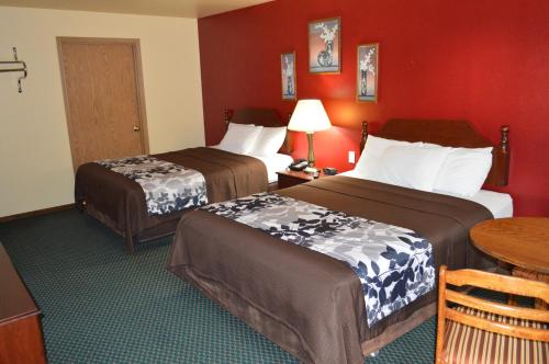 a hotel room with two beds and a table at Western Motel in Junction City