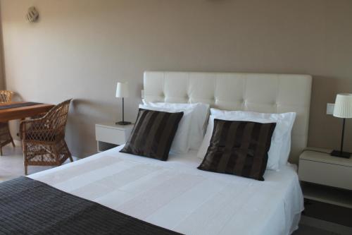 a bedroom with a white bed with two pillows at Vivenda Solmar in Lagos