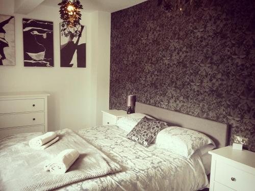a bedroom with a bed with a floral accent wall at Plough Cottage in Bradfield