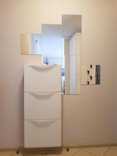 a white refrigerator in a room with a mirror at Nautilus 107 in Świnoujście