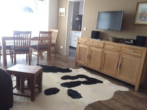 a living room with a television and a table and chairs at Ferienwohnung-Koehler in Altreichenau