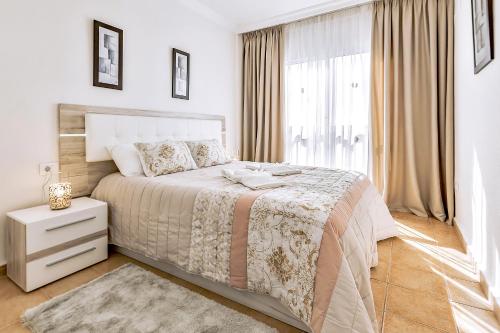 biała sypialnia z dużym łóżkiem i oknem w obiekcie Ocean Pearl Apartment w mieście Puerto de Santiago