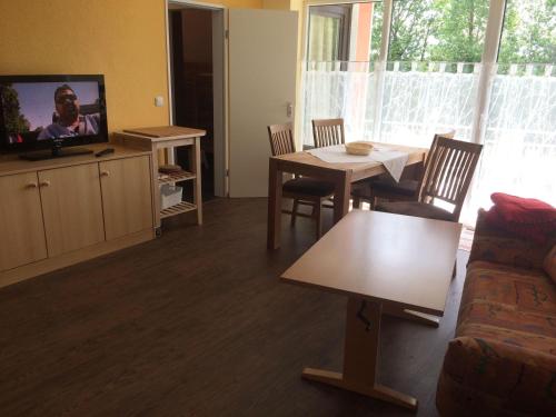 a living room with a couch and a table and a tv at Ferienwohnung-Putz in Altreichenau