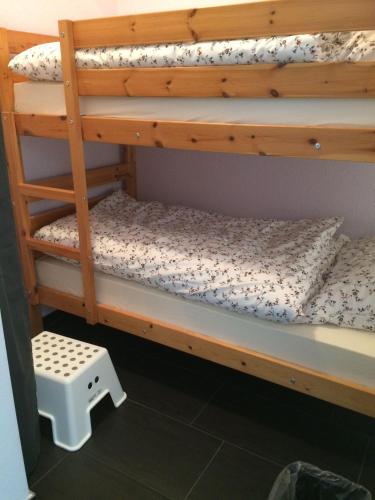 a bunk bed with a wooden bunk bed frame and a stool at Ferienwohnung-Putz in Altreichenau
