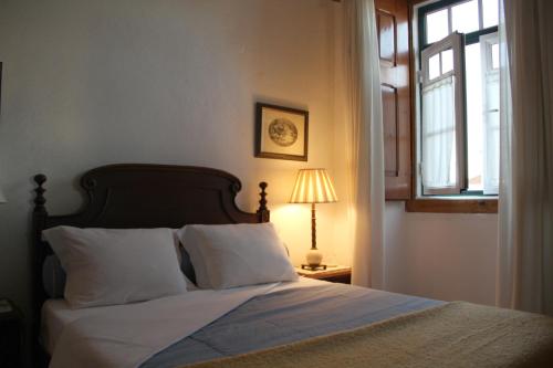 a bed in a bedroom with a window and a lamp at A Tejada in Ortiga