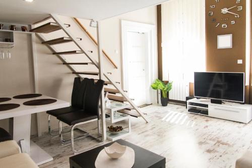 a living room with a staircase and a tv at R&R Apartment Dembinszky in Budapest