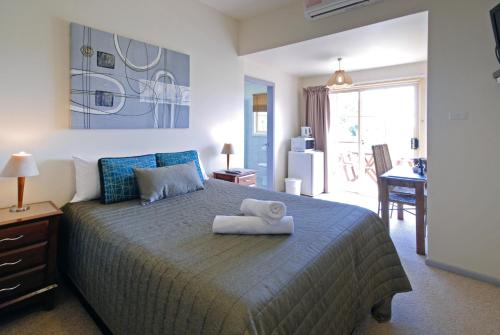 a bedroom with a bed with a towel on it at Riverview Boutique Motel in Nambucca Heads
