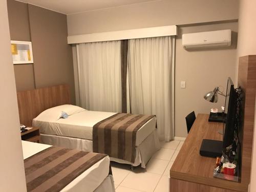 a hotel room with two beds and a television at Rio Stay Rio Centro in Rio de Janeiro