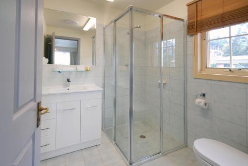 a bathroom with a shower and a sink and a toilet at Riverview Boutique Motel in Nambucca Heads