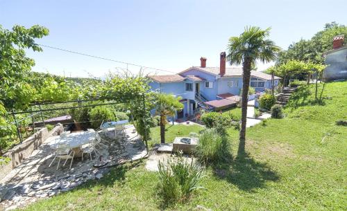 a house with a palm tree in a yard at Apartments Andela in Brseč