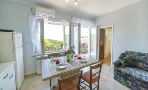 kuchnia i salon ze stołem i oknem w obiekcie Apartments Andela w mieście Brseč