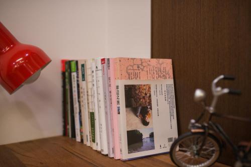 a row of books sitting on top of a shelf at Green Park Homestay in Luodong