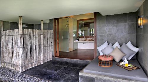 Habitación con ducha con almohadas y mesa. en The Longhouse, Jimbaran - Bali, en Jimbaran