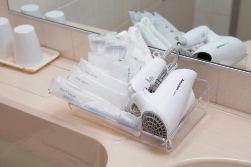 a pile of white toothbrushes sitting on a bathroom counter at Meitetsu Grand Hotel in Nagoya