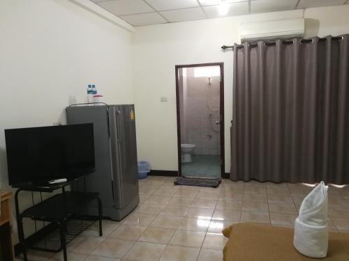 a living room with a television and a bathroom at Soi 5 Apartment in Pattaya