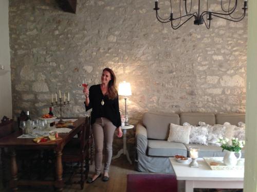 une femme tenant un verre de vin dans un salon dans l'établissement My Little French House, à Monflanquin
