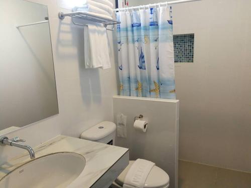 a bathroom with a sink and a toilet and a shower at Blue Shore Cottage in Pak Meng