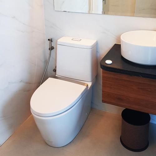 a bathroom with a white toilet and a sink at GQ Plaza in Kalibo