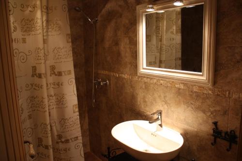y baño con lavabo y espejo. en Apartamentos El Jardín del Poeta, en Guijo de Granadilla