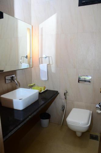 uma casa de banho com um lavatório e um WC em Upper Deck Resort em Lonavala