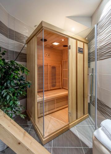 a wooden sauna with a glass door in a room at Hotel Varazdin in Varaždin
