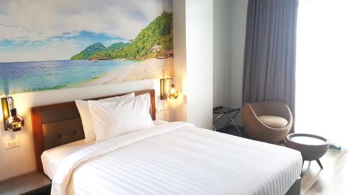 a hotel room with a bed and a painting of a beach at GQ Plaza in Kalibo
