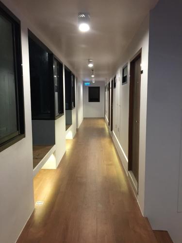 a hallway of an office building with wooden floors and windows at Red Door Samsen Hotel, Bangkok in Bangkok