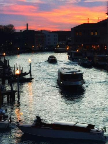 a group of boats in a river at sunset at homesweethome venice in Venice