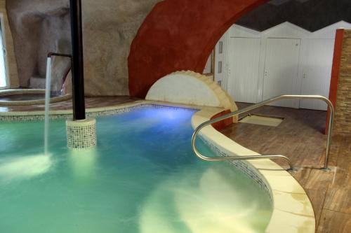 a swimming pool with a water slide in a room at Hotel La Font Vineuse & Spa in Saint-Pierre-dʼArgençon