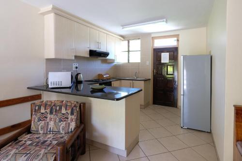 a kitchen with a counter and a refrigerator at Flamingo Holiday Flats in St Lucia